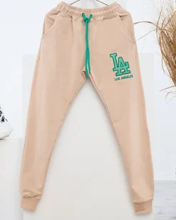 Royalfashion Beżowe damskie spodnie dresowe z kolorową naszywką