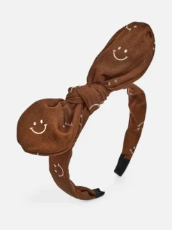 Royalfashion Dziecięca opaska do włosów z kokardką z printem w uśmiechnięte buźki