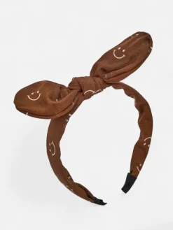 Royalfashion Dziecięca opaska do włosów z kokardką z printem w uśmiechnięte buźki