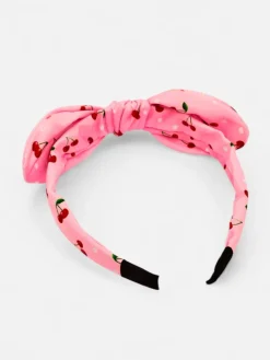 Royalfashion Dziecięca opaska do włosów z kokardką z printem w wisienki