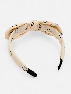 Royalfashion Dziecięca opaska do włosów z kokardką z printem w uśmiechnięte buźki