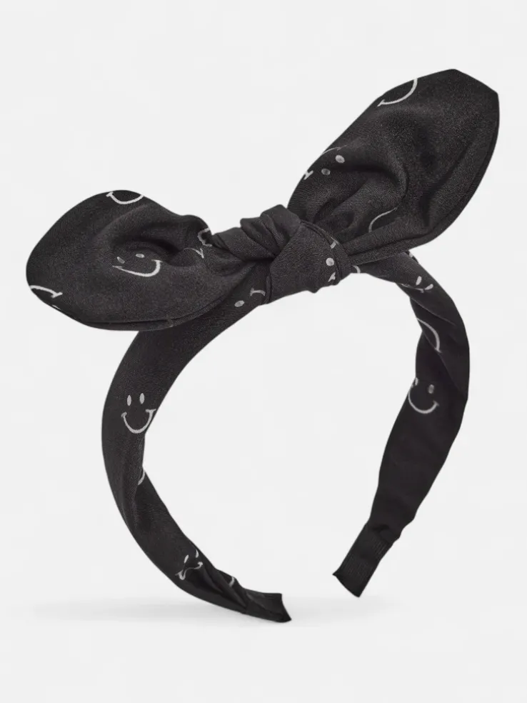 Royalfashion Dziecięca opaska do włosów z kokardką z printem w uśmiechnięte buźki